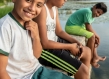 Children sitting on a riverbank smiling