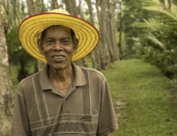 Man standing in a forest smiling